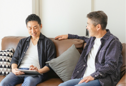 ソファに並んで会話する親子